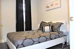 a bedroom with a bed with black and white pillows at Luxury Boutique 2 Bedroom Condo - 1B in Niagara Falls