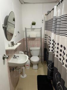 y baño con aseo, lavabo y espejo. en Casa rustica en Pulpos, en Lima