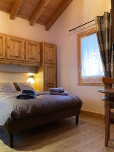 a bedroom with a bed with wooden cabinets and a window at Appartement neuf dans chalet idéalement situé, 5 couchages Prestations de qualité in Samoëns