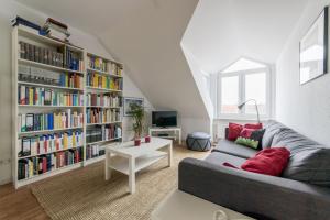 uma sala de estar com um sofá e uma estante de livros com livros em Private Rooms em Hanôver