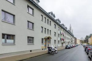 um edifício com uma moto estacionada ao lado de uma rua em Private Rooms em Hanôver