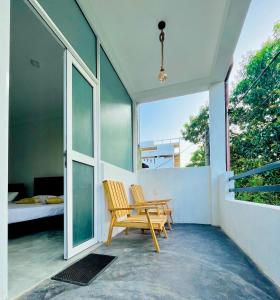 d'une terrasse avec une chaise en bois et un lit. dans l'établissement Surf & Salt, à Weligama