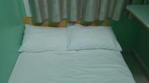 uma cama com lençóis brancos e almofadas num quarto em Ruby Star Hostel Dubai G P-34567 no Dubai
