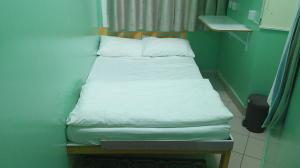 a small bed with white sheets and pillows in a room at Ruby Star Hostel Dubai G P-34567 in Dubai