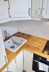 a white kitchen with a sink and a stove at Warsaw Concept in Warsaw