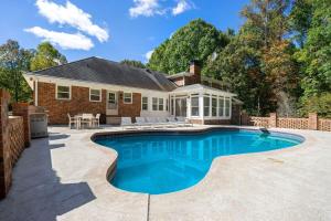 a swimming pool in front of a house at Grand Retreat - Luxury Vacation for Large Groups in Fayetteville