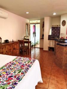 a room with a bed and a kitchen with a table at Casa Arbol de Paz Hab Sencilla in Chacala