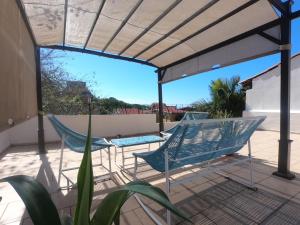 een patio met 2 stoelen en een pergola bij Casa Arbol de Paz Hab Sencilla in Chacala