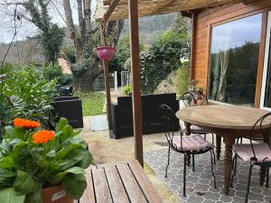 a patio with a table and chairs and flowers at La Cabane in Le Bar-sur-Loup