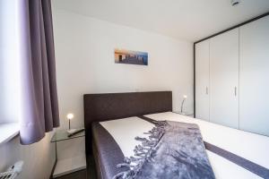a bedroom with a bed and a large mirror at Leuchtturm 10 in Großenbrode