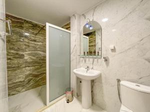 een witte badkamer met een wastafel en een douche bij Imperial Hotel in Ulcinj