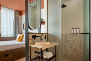 ein Bad mit einem Waschbecken und einer Dusche in der Unterkunft The Usual Rotterdam in Rotterdam