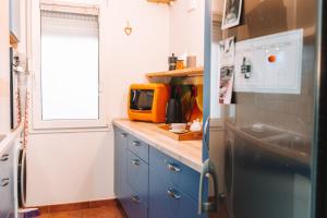 cocina con armarios azules y microondas en Apartment with Atrium Anabela, en Tolmin