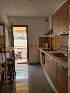 een keuken met houten kasten en uitzicht op een patio bij Apartamento con amplia terraza en Candelaria in Candelaria