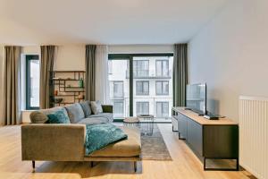 ein Wohnzimmer mit einem Sofa und einem TV in der Unterkunft Furnished 2 Bedroom Apartment in City Center in Brüssel