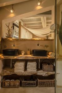 ein Badezimmer mit Waschbecken und Handtüchern auf einem Regal in der Unterkunft la Casa dei Gatti a Seccheto, una chicca in Seccheto + 28 Fotos