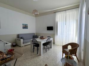 een woonkamer met een tafel en stoelen en een bank bij Casa Nonna Amalia in Terzigno