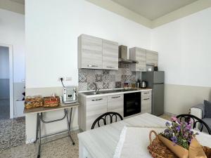een kleine keuken met witte kasten en een tafel met een tafel sidx sidx bij Casa Nonna Amalia in Terzigno