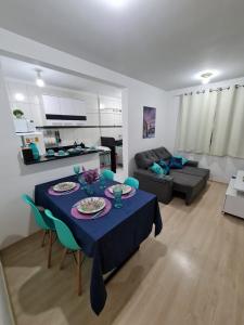 ein Wohnzimmer mit einem Tisch und einem blauen Tischtuch in der Unterkunft Apto Decorado 2 quartos c/ Estacion-Jd Nova Europa-Campinas in Campinas
