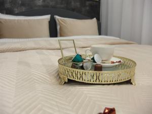 a tray with a coffee cup and other items on a bed at ZB Apartment GREY Bytom Centrum Piekary Sląskie Siemianowice Chorzów in Bytom