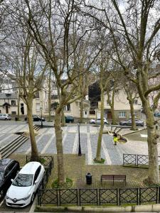 a white car parked in a parking lot with trees at Place St Vincent de Paul, Le Havre in Le Havre