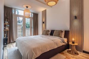 een slaapkamer met een groot bed en een raam bij CanalView Luxury Apartment in Amsterdam
