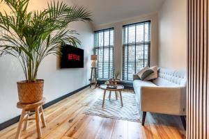 een woonkamer met een bank en een potplant bij CanalView Luxury Apartment in Amsterdam