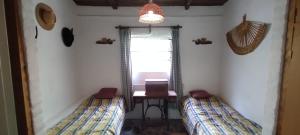 2 camas en una habitación con mesa y ventana en Hospedaje Serrano Suyuque Viejo en San Luis