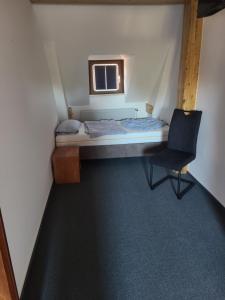 にあるGästehaus Harzstraßeの小さなベッドルーム(ベッド1台、椅子付)