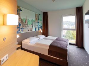 a hotel room with a bed and a window at B&B Hotel Marburg in Marburg an der Lahn