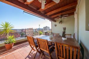 balkon z drewnianym stołem i krzesłami w obiekcie La Terrazza Sul Parco w mieście Quartu SantʼElena