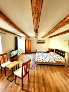 a bedroom with a bed and a table and a tv at Penzión Velická vináreň in Poprad