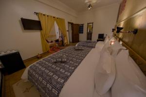 a bedroom with two beds with white sheets at Tin Joseph in Ouarzazate