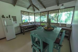 a kitchen with a blue table and a refrigerator at Jungle Dreamz in Manzanillo