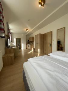 a bedroom with a large white bed and a bathroom at Hotel am Römerplatz in Ulm