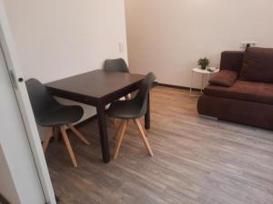 einem Esstisch mit 2 Stühlen und einem Sofa in der Unterkunft JiM Apartments in Wien