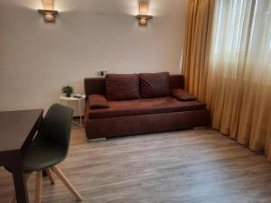 維也納的住宿－JiM Apartments，客厅配有棕色沙发和桌子