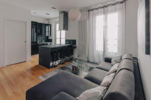 a living room with a couch and a kitchen at Casa Penelope in Milan