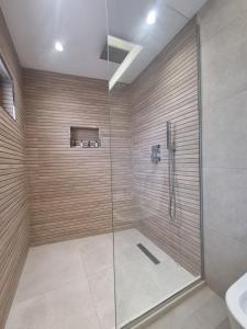 een badkamer met een douche met een glazen deur bij HOTEL VILA TWIX in Berat +37 foto's