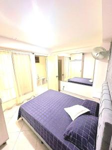 1 dormitorio con 1 cama azul y 2 ventanas en Amplio y lindo apartamento, en Medellín