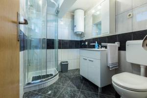 a bathroom with a shower and a toilet and a sink at Apartments Villa Bosotina in Kukljica +84 photos