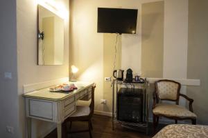 a room with a desk and a television and a chair at Il Cortiletto in Piacenza