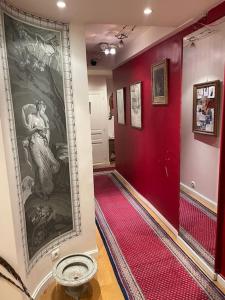 a hallway with red walls and a painting on the wall at Appartement Versailles château in Versailles