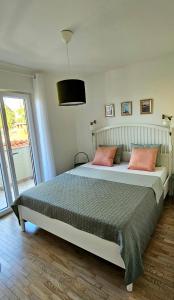 1 dormitorio con 1 cama grande y 2 almohadas rosas en Apartment Big blue, en Maslenica