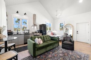 uma sala de estar com um sofá verde e uma cozinha em Romeo y Julieta by Brightwild Steps to 7th Ave em Tampa