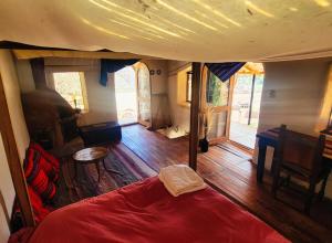 een slaapkamer met een rood bed in een kamer met houten vloeren bij Wolf Totem Mountain Top Dream Villa in Pisac