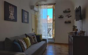 uma sala de estar com um sofá e uma janela em L'Appartement dans les Venelles em Cefalù