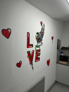 a wall with hearts and the word love on it at 2-Bedroom Flat w/ En-Suites, Perfect for Groups in Liverpool