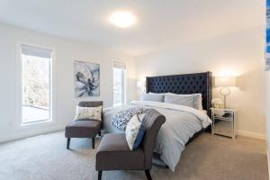 a bedroom with a large bed and a chair at Bluewaters in Kensington in Calgary