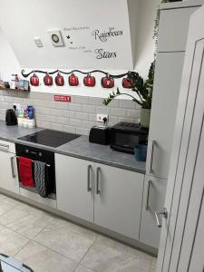 a kitchen with red apples on the wall at 2-Bedroom Flat w/ En-Suites, Perfect for Groups in Liverpool